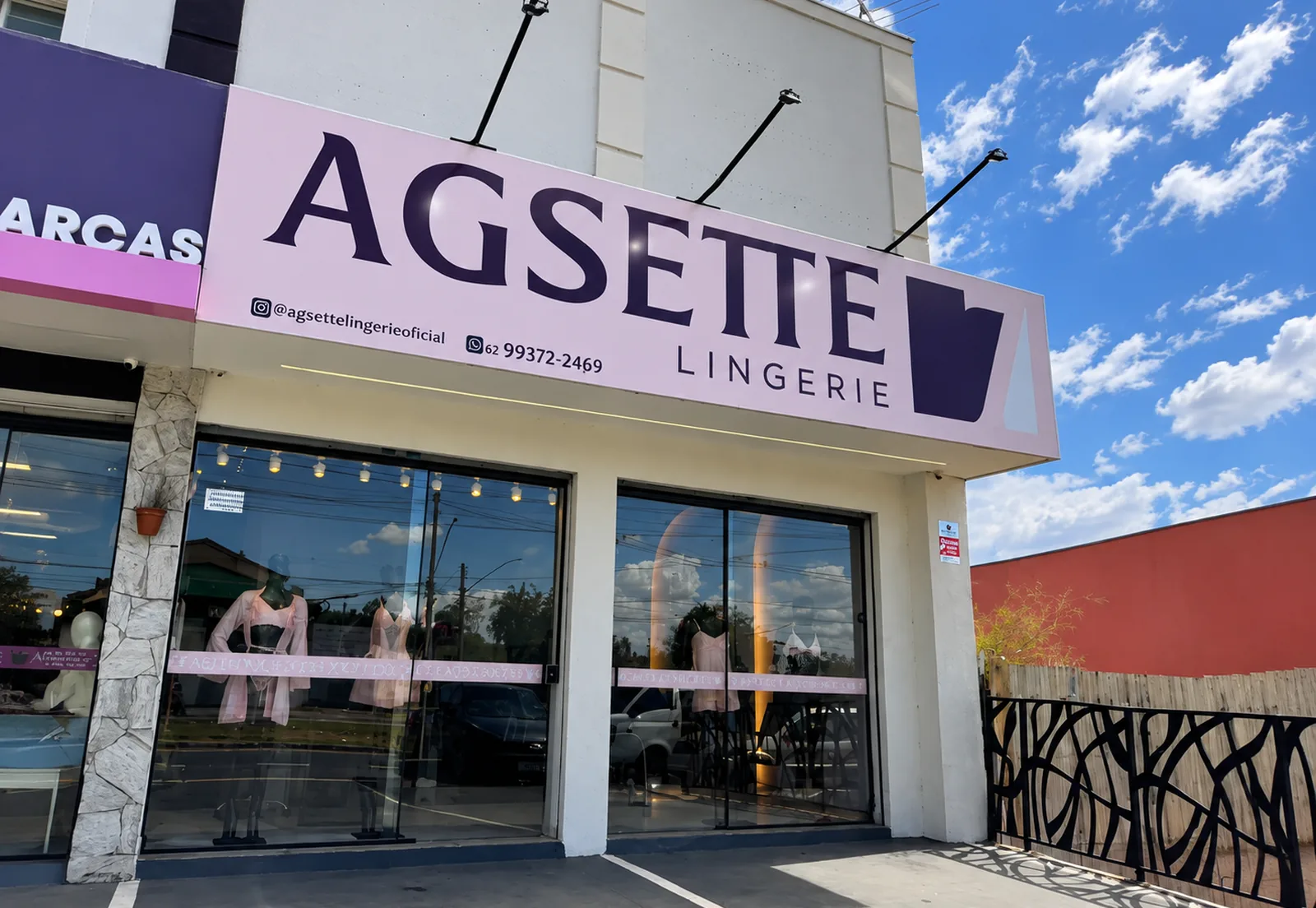 Fachada iluminada da loja física Agsette Lingerie ao entardecer